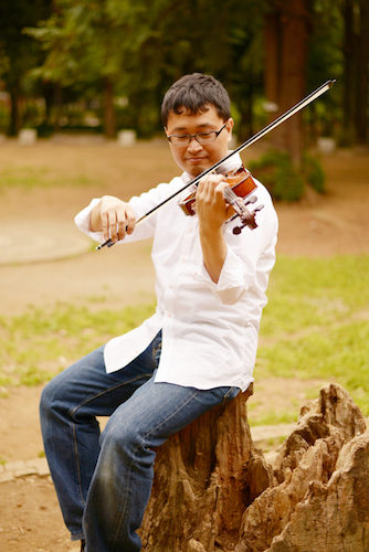 切り株に腰掛けてヴァイオリンを演奏している・いちろーたの写真